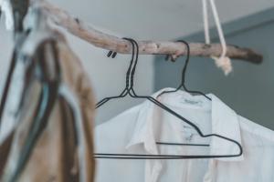 a white shirt is hanging on a clothes rack at FURU Hostel & Café in Bøstad