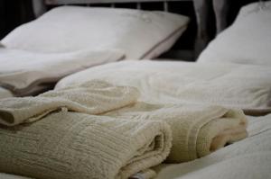 a white blanket and pillows on a bed at Drinska laguna in Banja Koviljača