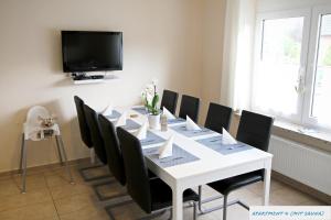 comedor con mesa blanca y sillas negras en Ferienhaus Seeschwalbe, en Tossens