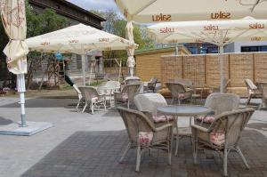 een patio met tafels, stoelen en parasols bij Villa & Restoran Soffa in Haapsalu