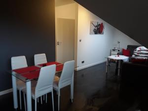 シュツァブニツァにあるApartament Homole B5 nad Grajcarkiemのダイニングルーム(赤いテーブル、白い椅子付)