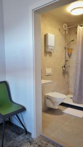 a bathroom with a shower and a toilet and a chair at Höfn Hostel in Höfn