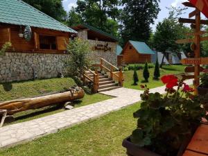 a log cabin with a garden and a house at Rafting Tara Camp Highlander in Bastasi