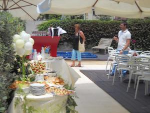 a man and a woman standing next to a table with food at Le Formiche in Milazzo
