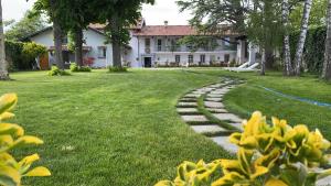 un jardín con un camino de piedra frente a una casa en ANTICA VILLA - Guest House & Hammam - Servizi come un Hotel a Cuneo, en Cuneo