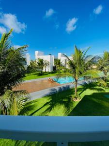 uma vista para uma piscina com palmeiras em B Blue Beachouses em Itacimirim