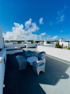 eine Terrasse mit Stühlen und Tischen auf dem Dach in der Unterkunft B Blue Beachouses in Itacimirim