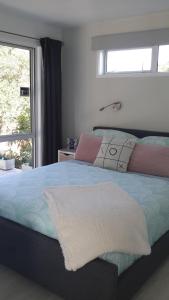 a bedroom with a large bed with a window at Four Huia in Oneroa