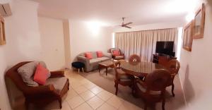 a living room filled with furniture and a tv at Rose Bay Resort in Bowen