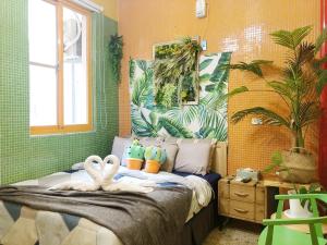a bedroom with a bed with two swans on it at Sennong Homestay in Tainan