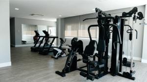 a gym with several tread machines in a room at Hotel Alvorada in Concordia