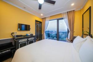 a hotel room with a large bed and a window at Athenia Hoi An Boutique Hotel & Spa in Hoi An