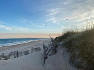 a sandy beach with a fence and the ocean at NC 12 56821-8 Condo in Hatteras