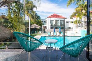 a patio with a table and chairs next to a pool at Terrigal Pacific Coastal Retreat in Terrigal