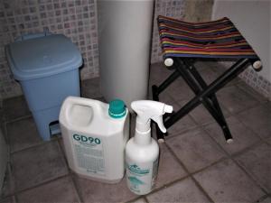 eine Flasche Bleichmittel neben einem Stuhl und eine Mülltonne in der Unterkunft La Pietra Rara B&B in Montone