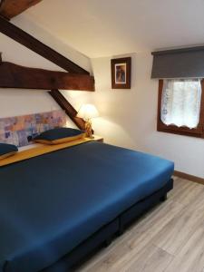 a bedroom with a blue bed in a room at La Posada in Ambierle