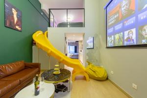 un salon avec un toboggan jaune dans l'établissement loft Apartment with slide hammock with movie viewing, à Hangzhou
