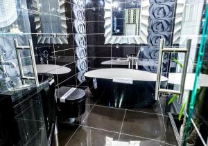 a black and white bathroom with two sinks and a tub at Polonia in Ostrów Wielkopolski