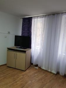 un soggiorno con tende bianche e TV di Apartament Diara a Sibiu