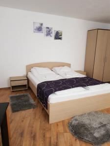 una camera con letto e pavimento in legno di Apartament Diara a Sibiu