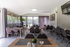 a conference room with tables and chairs and windows at Motel OLIV in Oświęcim