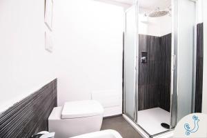 bagno con doccia e servizi igienici bianchi di Scuderie Reali - Loft in Castello, old town a Cagliari