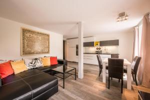 因特拉肯Dependance West的客厅里有一张黑色沙发和一张桌子