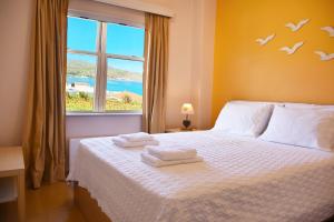 a bedroom with a bed with two towels on it at Andros Apartment - Lasia in Andros