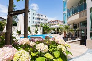a garden of flowers in front of a swimming pool at Zevs Residence in Nesebar