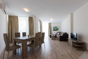 a living room with a dining room table and a couch at Zevs Residence in Nesebar