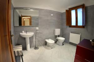 uma casa de banho com 2 WC, um lavatório e um espelho. em Podere Assolatina Agriturismo em San Casciano dei Bagni