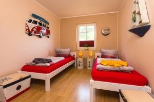 two beds in a room with a van on the wall at Waldidyll in Ostseebad Karlshagen