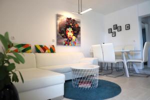 sala de estar con sofá blanco y mesa en Apartments Skandi1, en Malinska