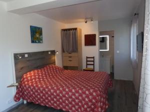 um quarto com uma cama com um cobertor vermelho em Chambre d'Hôtes L'Odalyre em Moustiers-Sainte-Marie