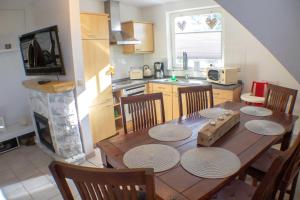 eine Küche mit einem Holztisch mit Stühlen und einem Kamin in der Unterkunft Ferienwohnung Ostseefeeling 3 in Ostseebad Karlshagen