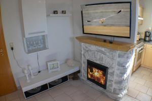 ein Wohnzimmer mit einem TV auf dem Kamin in der Unterkunft Ferienwohnung Ostseefeeling 3 in Ostseebad Karlshagen