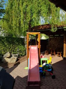 einen Spielplatz mit einer roten Rutsche und einer Spielstruktur in der Unterkunft Sabbia Ristorante - Reštaurácia a Ubytovanie Prievidza in Prievidza