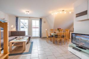 a living room with a couch and a tv and a table at Ferienwohnung Ostseefeeling 4 in Ostseebad Karlshagen