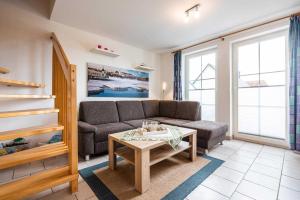 a living room with a couch and a table at Ferienwohnung Ostseefeeling 4 in Ostseebad Karlshagen +12 photos