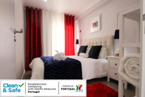 een witte slaapkamer met rode gordijnen en een bed bij Ferhouse Dreams-Farilhões in Nazaré