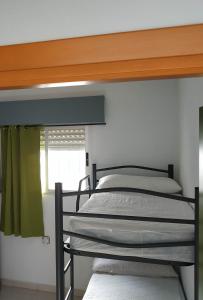 2 Etagenbetten in einem Zimmer mit Fenster in der Unterkunft Albergue de San Jose in San José