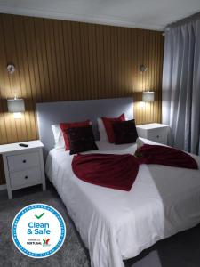 um quarto com uma grande cama branca com almofadas vermelhas em Casa da Leninha na Nazaré