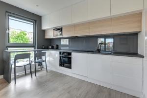 uma cozinha com armários brancos e uma bancada em The Darling Nadmorze by Baltica Apartments em Gdansk