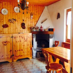 comedor con mesa y chimenea en S.Stefano d’Aveto: relax in montagna, en Santo Stefano dʼAveto