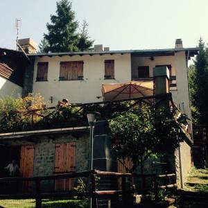 una casa vieja con ventanas tapiadas y un árbol en S.Stefano d’Aveto: relax in montagna, en Santo Stefano dʼAveto