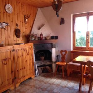 cocina con chimenea y mesa en una habitación en S.Stefano d’Aveto: relax in montagna, en Santo Stefano dʼAveto