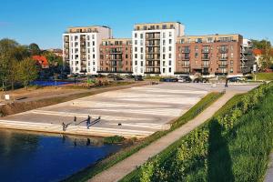 a group of people walking on a sidewalk next to a body of water at No.1 Apartment Link-To-Happiness in Klaipėda +30 photos