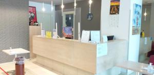 a store with a reception counter in a room at Hotel Lux in Modena