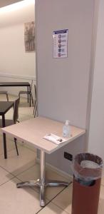 a table in a room with a trash can at Hotel Lux in Modena