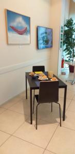 una mesa y sillas en una habitación con una pintura en Hotel Lux, en Módena